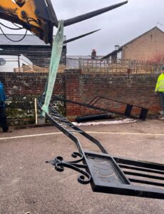 iron archway being lifted by machine