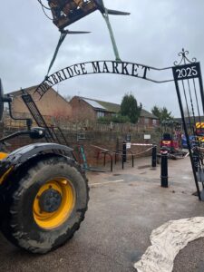 iron archway with words Edenbridge Market being lifted by crane