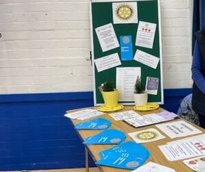 Table with leaflets displayed from Rotary Club with blue wall in background