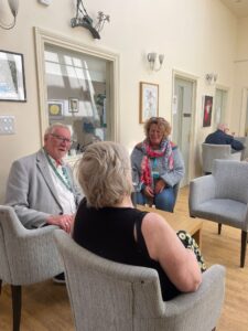male and female councillor sitting in chairs talking to a resident