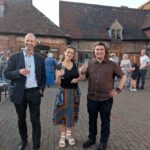 Three people standing raising a glass of wine in their hands