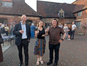 Three people standing raising a glass of wine in their hands