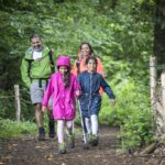 family wearing coats walking in the woods