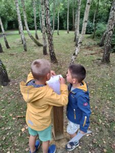 two boys in the wood drawing a sketch