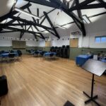 Interior of hall with wooden floor, tables and chairs and bunting