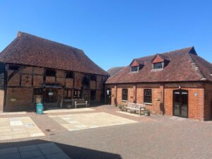 exterior of brick building with tiled roof and benches in font and blue sky
