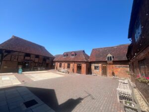 exterior of brick building with tiled roof and benches in font and blue sky