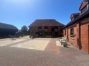 exterior of brick building with tiled roof and benches in font and blue sky