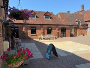 brick building in courtyard with hanging flower baskets