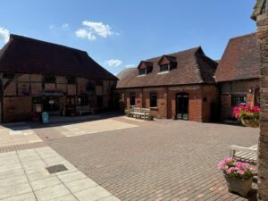 brick building in courtyard with hanging flower baskets
