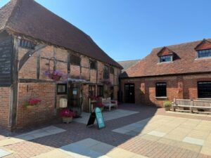 brick building in courtyard with hanging flower baskets