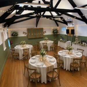 generated image of a hall room set up with tables and chairs and flowers with white decor for a wedding and just married bunting